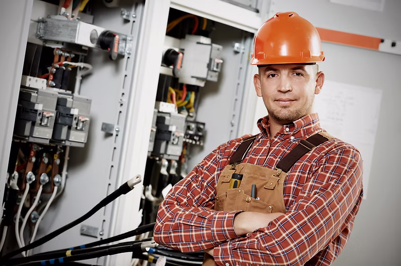 Electrical services technician working on a panel